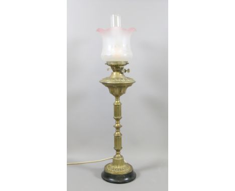 A large brass based oil lamp, converted to electricity with etched glass shade and chimney.