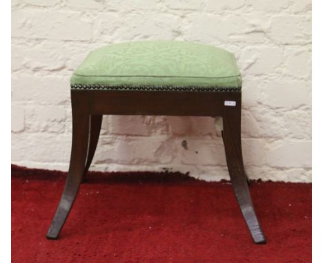 An antique re-upholstered walnut stool raised on splayed legs.