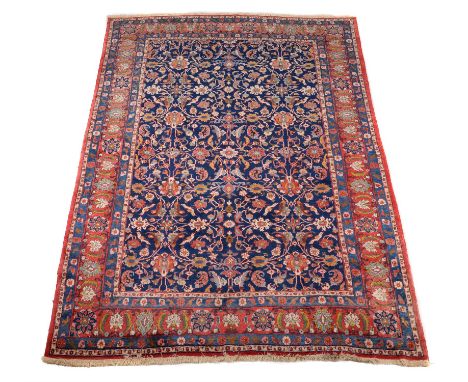 A Varamin carpet, the dark blue field decorated with an overall design of flowering foliage, within a madder border decorated