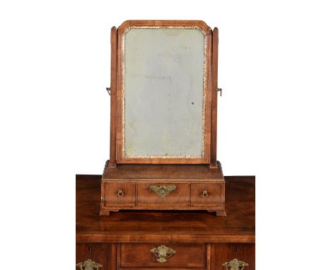 A George II walnut dressing mirror, circa 1735, the rectangular plate within the gilt cut gesso sight edge and frame, the bas