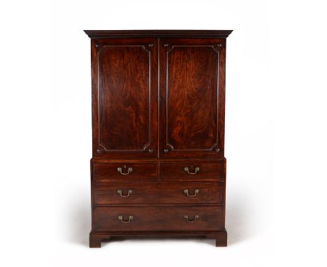 A George III mahogany clothes press, circa 1770, in the manner of Thomas Chippendale, the dentil moulded cornice above a pair