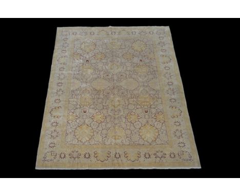 A Ziegler carpet, the red field and borders decorated with stylised foliate motifs in tones of cream and pale ochre, approxim