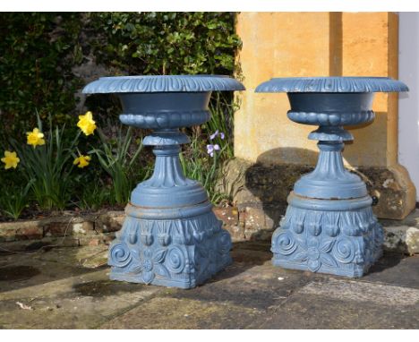A pair of Victorian blue painted cast iron garden urns on plinths, later 19th century, each everted circular basin with egg-a