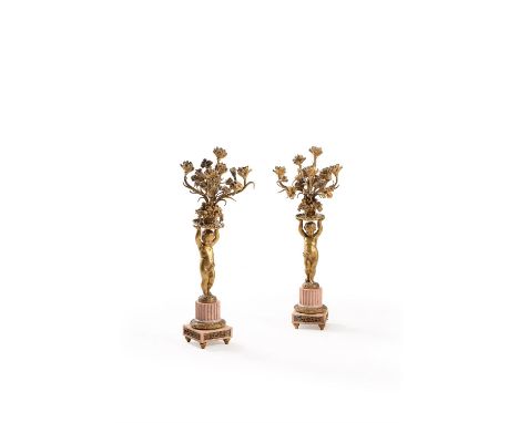 A pair of French gilt metal and marble mounted five light figural candelabra, last quarter 19th century, probably previously 