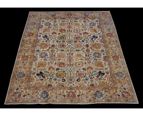 A Tabriz carpet, the cream field decorated with an overall design of meandering floral branches, within a similarly decorated