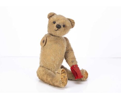 An early German teddy bear circa 1910, with blonde mohair, black boot button eyes, pronounced muzzle, black stitched nose, mo