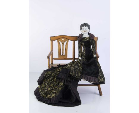 An unusual 19th century German china shoulder head doll, with black painted and moulded hair, curls spilling onto the forehea