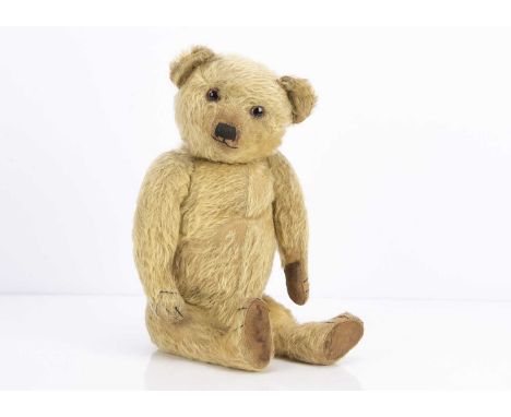 A 1920s Terry-type teddy bear, with blonde mohair, clear and black oily eyes, with orange painted backs, pronounced muzzle, b