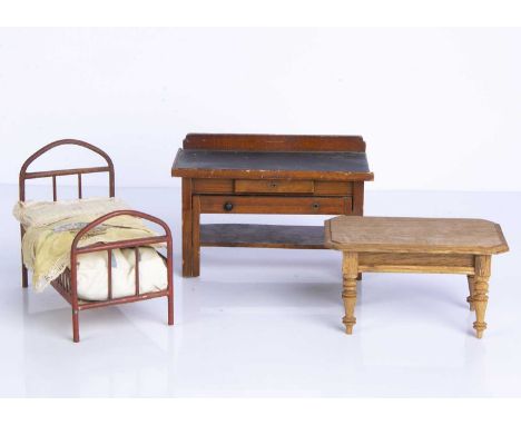 Large scale dolls’ house furniture, a red tinplate bed —6in. (15cm.) long; an oak table; and an unusual workbench with slide 