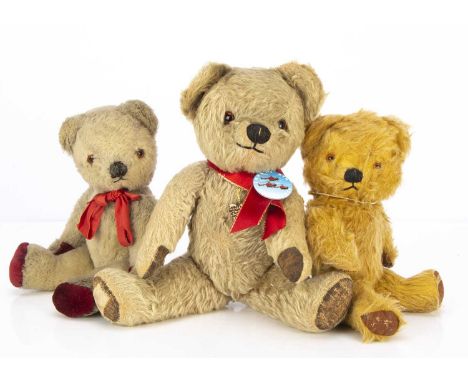 Three post- war Chad Valley teddy bears, the largest with blonde mohair, orange and black glass eyes, black stitched nose, mo