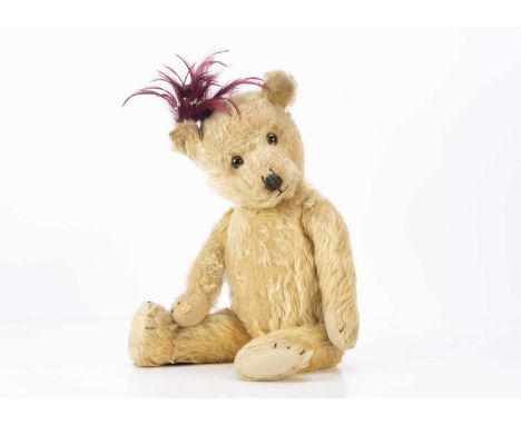 A 1930s Chiltern-type teddy bear, with blonde mohair, orange and black glass eyes, black stitched nose, mouth and claws, swiv