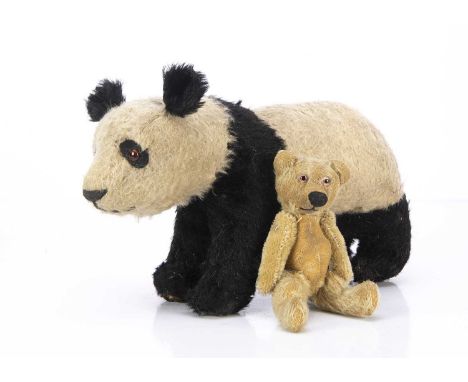 Two 1930s British teddy bears,  a black and white mohair panda on all fours, oranged and black glass eyes, black felt discs b