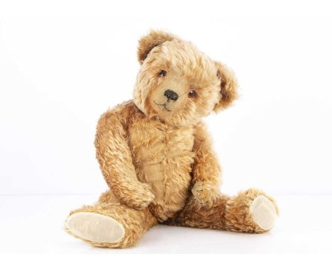 A light cinnamon mohair 1930s teddy bear, with orange and black glass spike eyes, black stitched nose mouth and claws, swivel