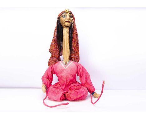 An Indian female puppet, with painted papier-mache head, hinged mouth, stuffed body, on pole making her neck extend, original