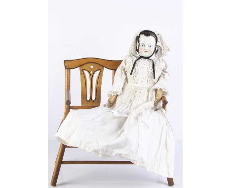 An unusual 19th century German china shoulder head doll, with brown painted and moulded hair pulled back in an Alice band and