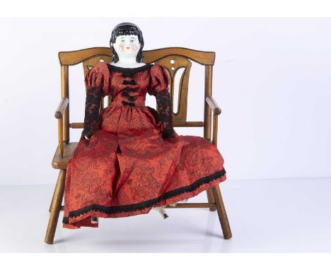 A 19th century German china shoulder-head doll, with blue painted eyes, exposed ears, black painted and moulded hair with fri