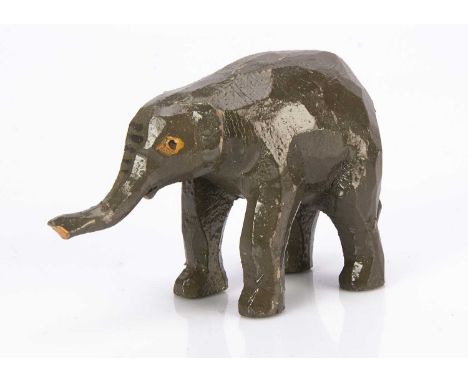 A Forest Toys of Brockenhurst baby elephant, carved and grey painted wood with raised trunk —4 1/2in. (11.5cm.) long (slight 