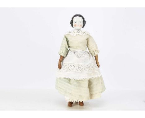 An A W Kister china shoulder head doll, with blue painted eyes, red eyelid line, black painted and moulded centre-parted hair