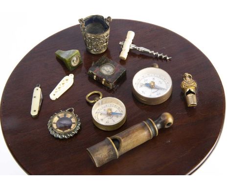 Whistles and compases, a small gilt metal whistle —1 1/4in. (3cm.) long; and a horn whistle; five compass; a thimble holder; 