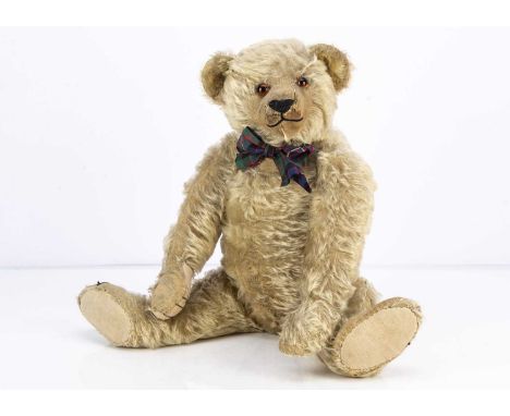 A 1920s J K Farnell teddy bear, with blonde mohair, replacement orange and black glass eyes, pronounced clipped muzzle, black