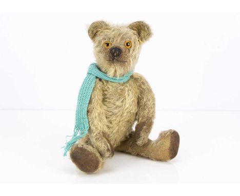 A 1920s Chad Valley moon eyed teddy bear, with blonde mohair, orange and black glass moon eyes, pronounced muzzle, black stit