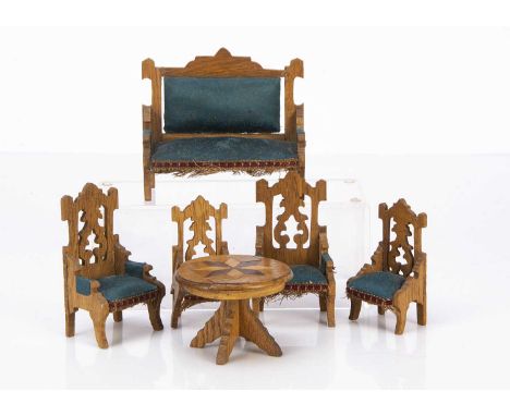 An early 20th century oak dolls’ house sitting room set, a sofa, two armchairs and two chairs, fretwork Gothic backs and gree