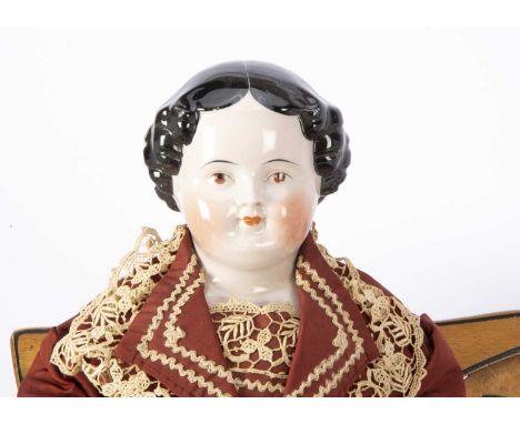 A 19th German china shoulder head pink tinted doll, with brown painted eyes, red eyelid line, closed mouth, black painted and