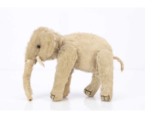 A rare Steiff white mohair jointed Elephant 1907-1916, with black boot button eyes, felt tusks, swivel head, jointed legs, bl