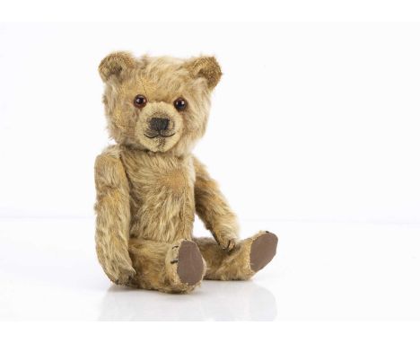 A 1950s Chiltern Ting-A-Ling teddy bear, with blonde mohair, orange and black glass eyes, black stitched nose, mouth and claw