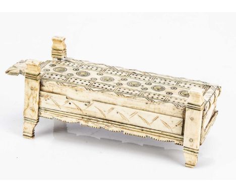 An early 19th century bone prisoner of war domino and cribbage marker box,  rectangular on legs with sliding lid containing a