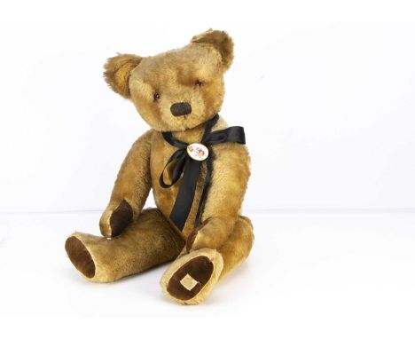 A large post-war Chad Valley teddy bear, with blonde mohair, orange and black glass eyes,  black stitched nose, mouth, swivel