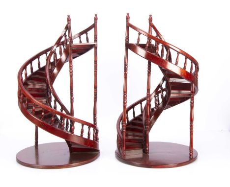 A pair of recent wooden spiral staircase doll or shopwindow display stands, red varnished, with turned balusters and sweeping