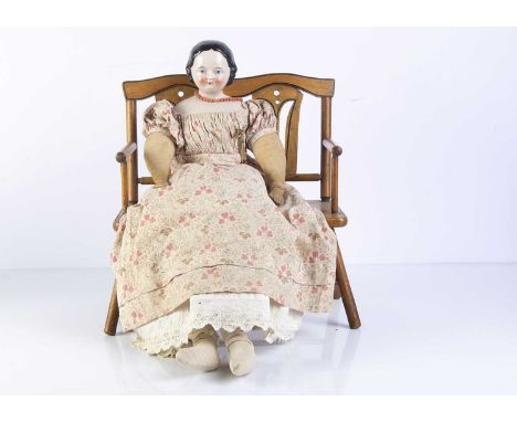 A 19th century pink tinted china shoulder head doll, with blue painted eyes, red eyelid line, black painted and moulded centr