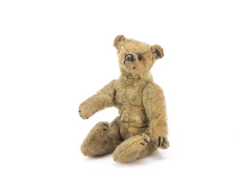 A small Steiff teddy bear circa 1910, with blonde mohair, black boot button eyes, pronounced muzzle, black stitched nose, mou