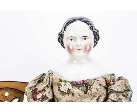 A large 19th century German china shoulder-head doll, with brown painted eyes, red eyelid line and curl to inner corner of ey