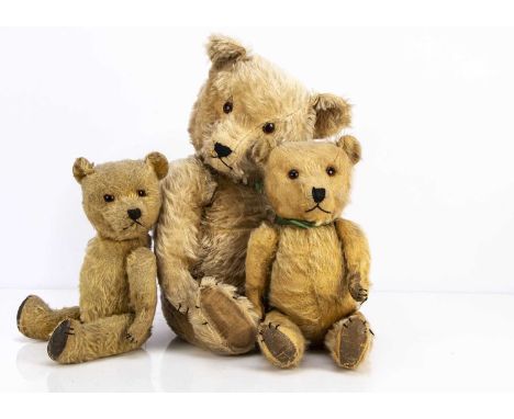 Three post-war Chiltern Hugmee teddy bears,  the largest with blonde mohair, orange and black plastic eyes, black stitched no