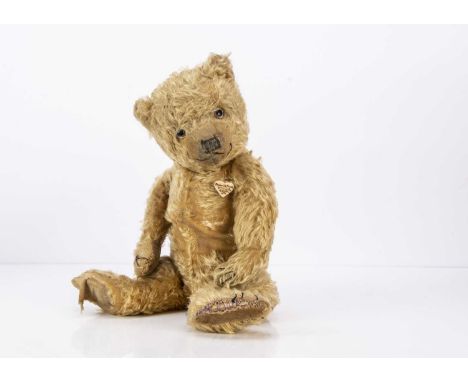 A 1930s Chiltern teddy bear, with golden mohair, clear and black glass eyes, black stitched nose, mouth and claws, swivel hea