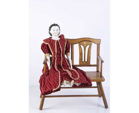 An unusual 19th century German china shoulder head doll, with blue painted upward glancing eyes, pink eyelid, small red paint