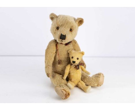 Two Chiltern type teddy bears,  the larger with blonde mohair, orange and black glass eyes, black stitched nose, mouth and cl