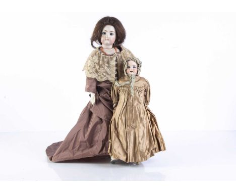 A small Armand Marseille 1894 shoulder-head doll,  with fixed blue glass eyes, gusseted kid body and old gold silk satin dres