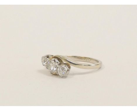 Diamond cross-over ring with three brilliants, the largest approx .30ct in white gold. '18ct'. Size 'K',&nbsp; 3.1g 
