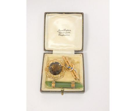 Three gold brooches to include a 9ct gold smoky quartz celtic twist brooch, gold nephrite brooch, and a seed pearl and sapphi