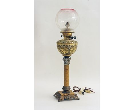 A Victorian brass table oil lamp, the double burner oil container with repousse decorations on a marble Corinthian column wit