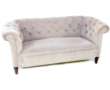 A Chesterfield two seater settee, early 20th century, upholstered in button back beige fabric, raised on unusual tapering and