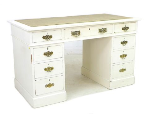 A late Victorian mahogany pedestal desk, painted white, with nine drawers, brass handles, and cream leatherette surface, 119 