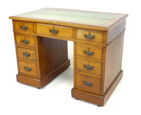 An Edwardian walnut twin pedestal desk, with green leather surface, nine drawers with brass handles, 106 by 66 by 76cm high. 