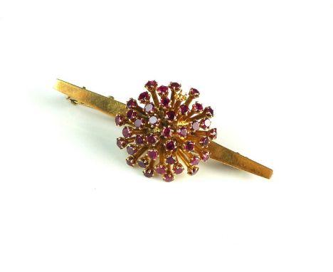 A ruby set stylised star burst bar brooch, designed as a raised cluster of round mixed cut rubies each claw set to yellow met