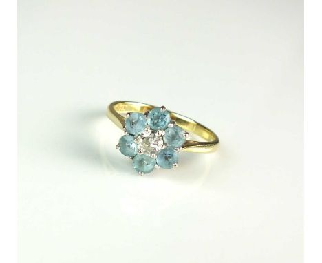 An 18ct gold diamond and aquamarine floral cluster ring, designed as a central brilliant cut diamond claw set in white gold w