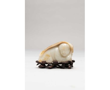 A CHINESE PALE CELADON JADE CARVING OF A BOY QING DYNASTY OR LATERHe crouches down and hides beneath a large banana leaf that