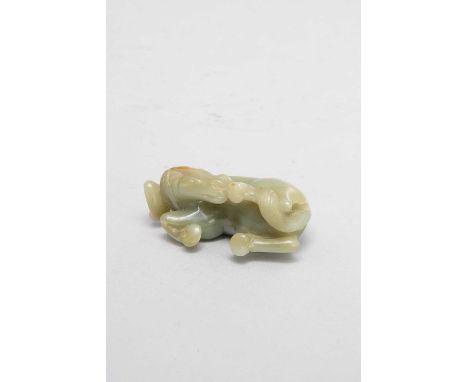 A CHINESE CELADON JADE MODEL OF A HORSE QING DYNASTY OR LATERIt sits with its neck curved round and biting his rear hoof, 8cm